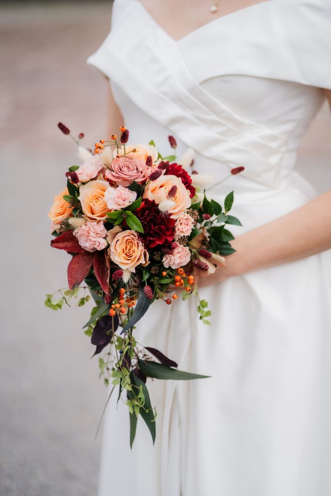 farbenfroher Blumenstrauß mit roten und lachsfarbenen Rosen